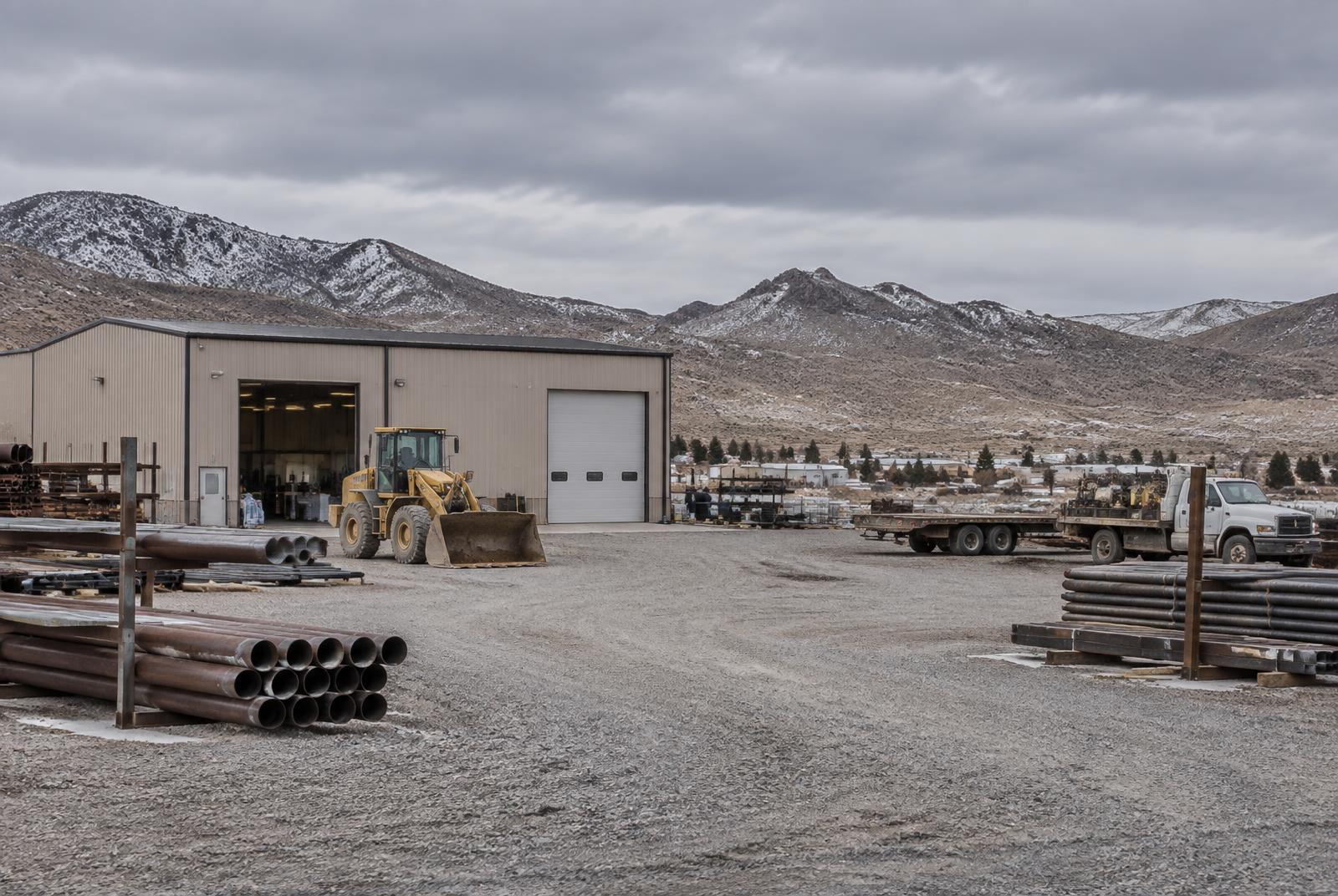 Industrial contractor yard with a metal shop building and equipment in Northern Nevada